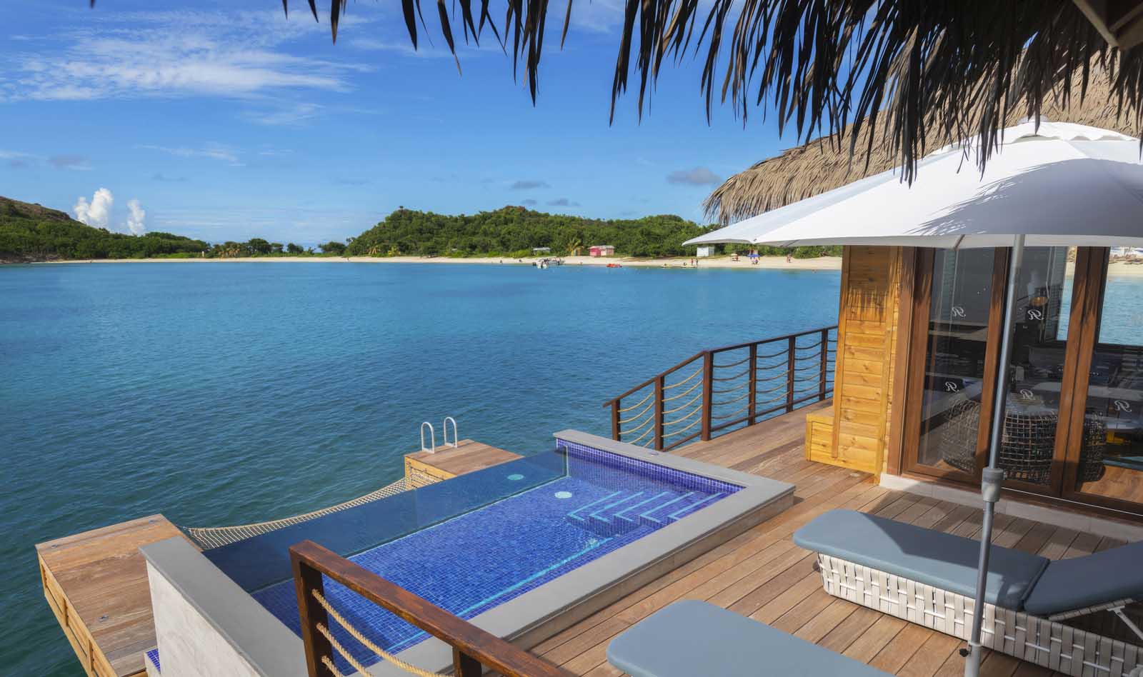 Chairman’s Overwater Bungalow at Royalton Antigua with king-size bed, infinity pool, and oceanfront deck