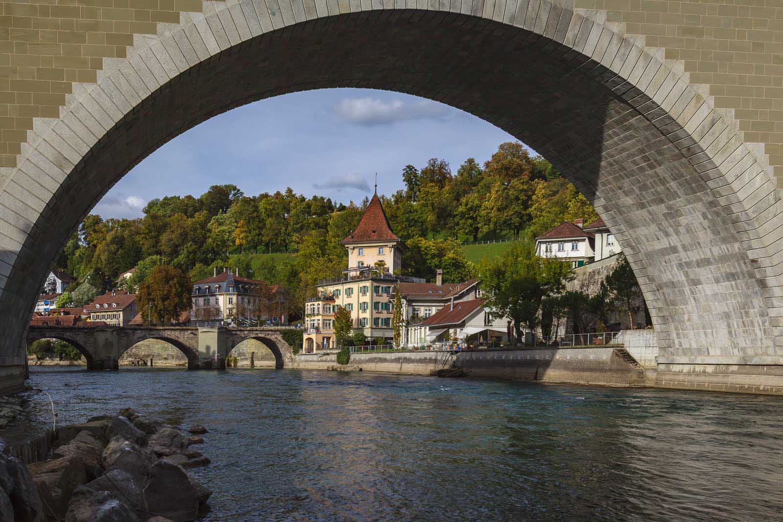 View of Bern’s medieval city center and Aare River framed under a stone bridge