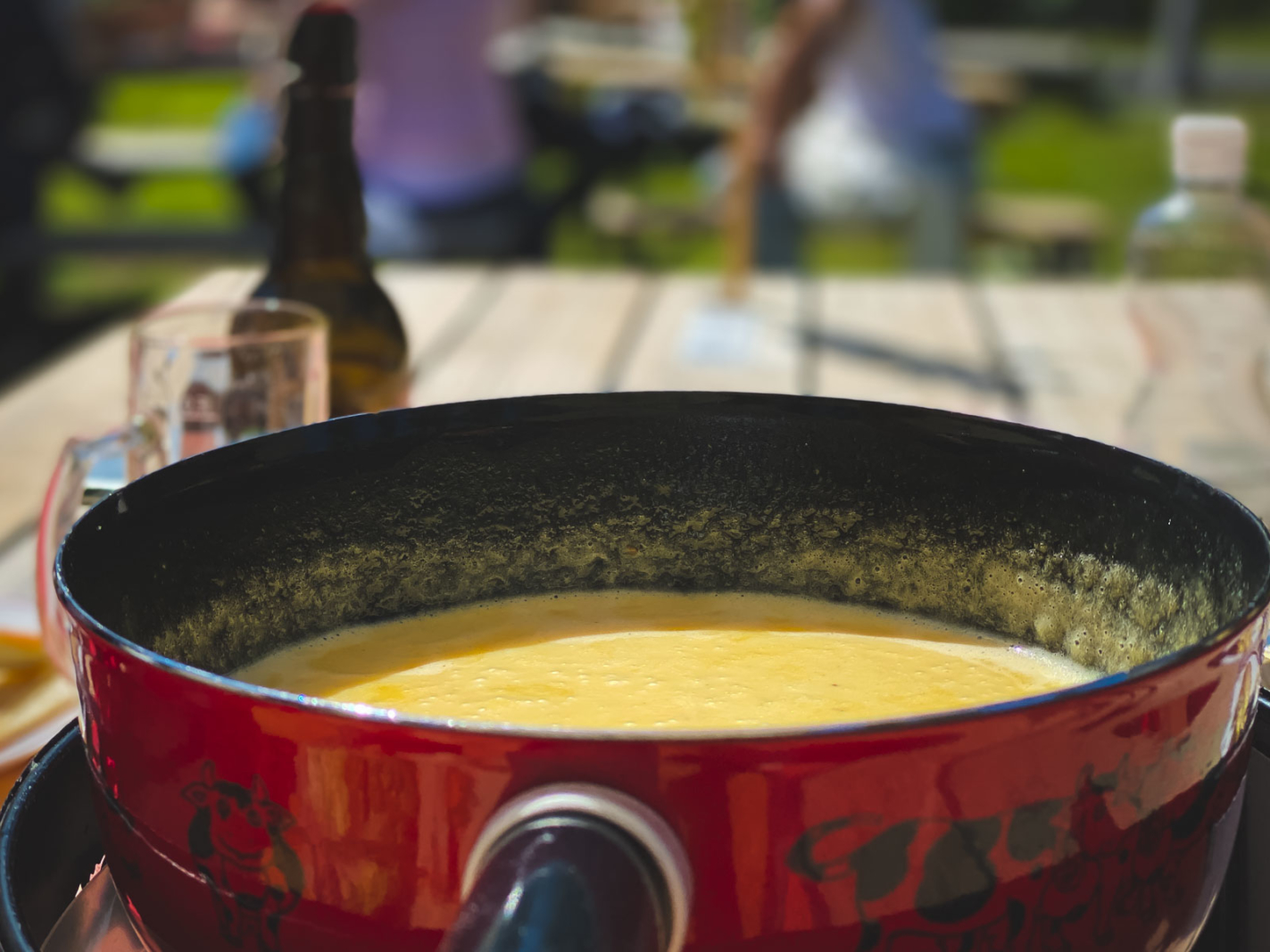 Cheese fondue pot outdoors in Gruyères – traditional Swiss lunch