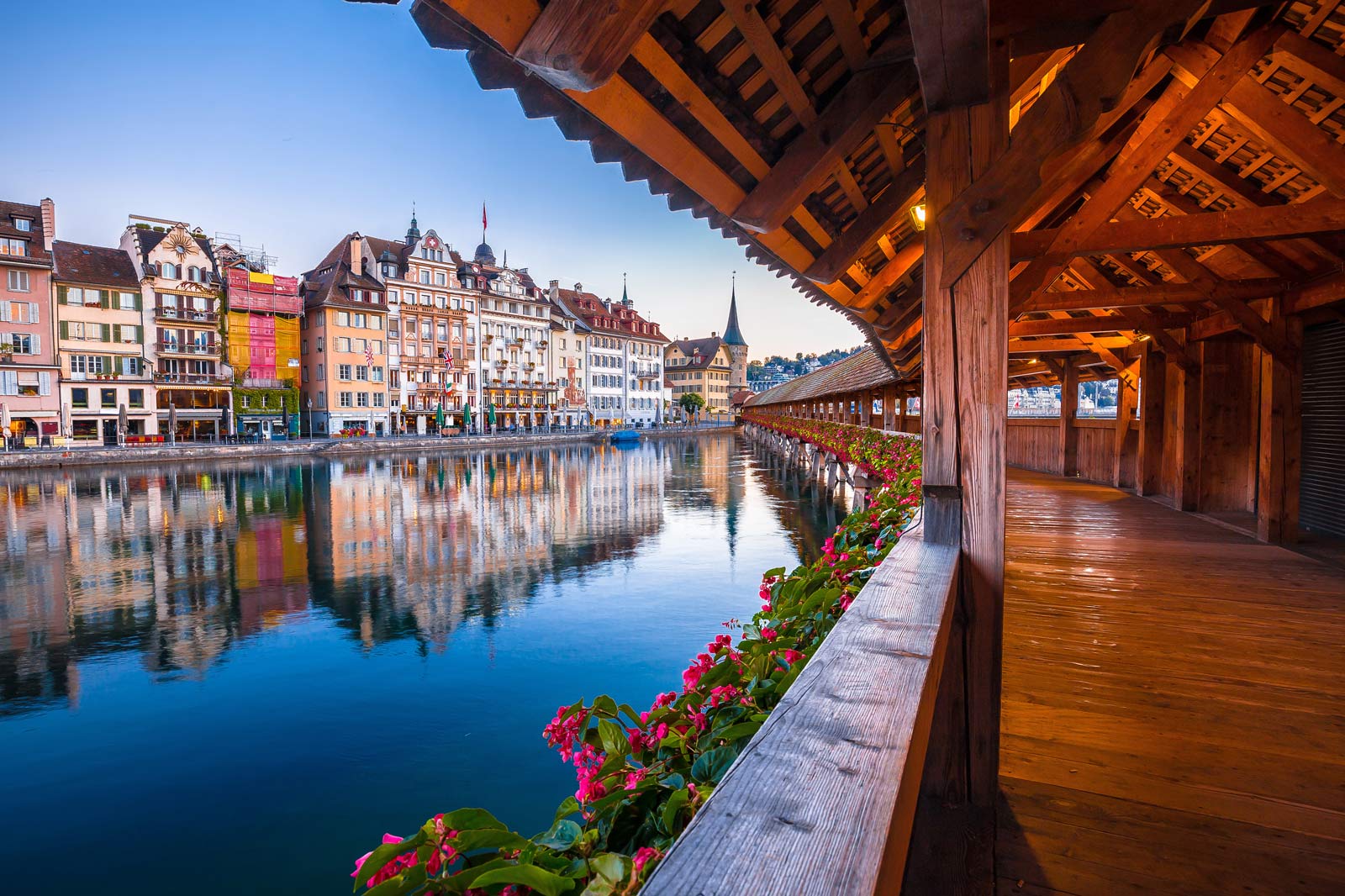 view from inside Lucerne’s wooden Chapel Bridge overlooking colorful Old Town buildings
