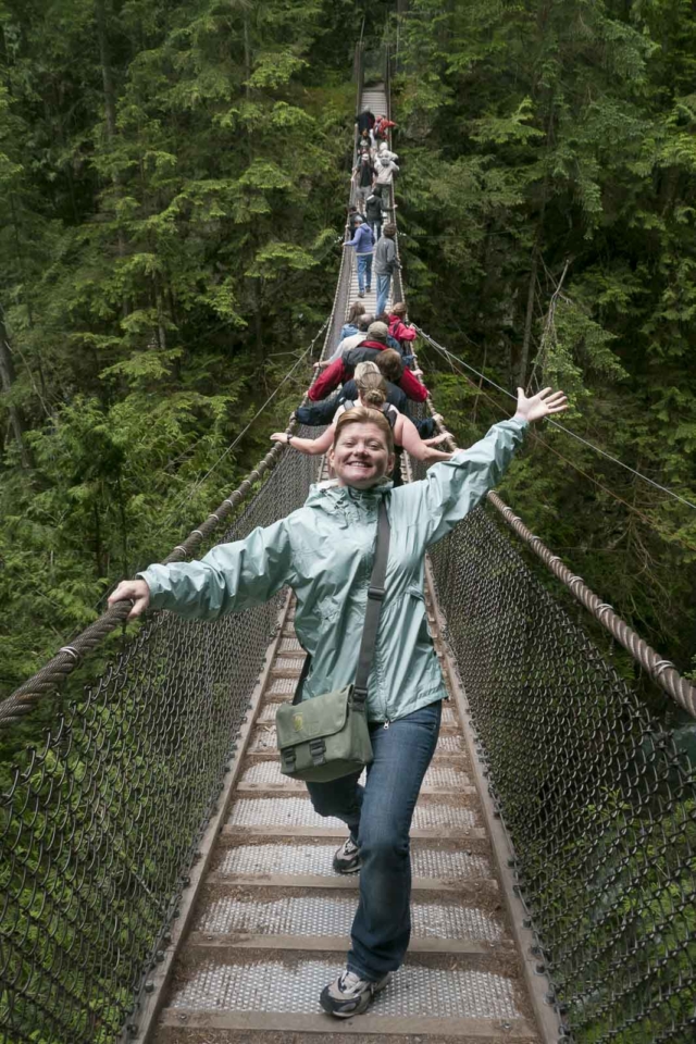 A woman is standing on the Capilano suspension Bridge