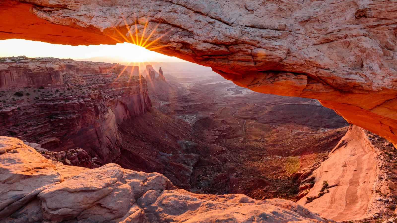 The morning sun glowing through the iconic Mesa Arch in Canyonlands National Park, Utah.