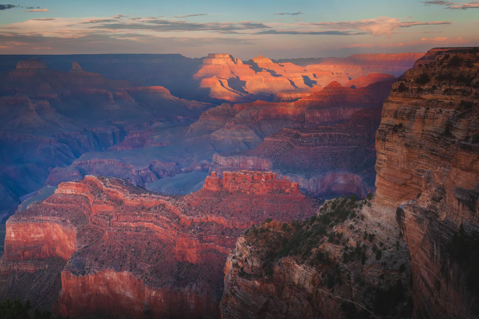 Looking out from the South Rim over the vast and layered Grand Canyon at sunset.