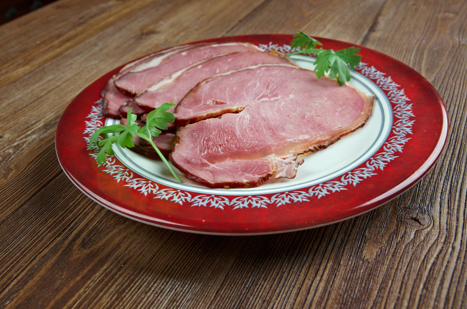 Slices of hangikjöt smoked lamb served with potatoes, peas, and Icelandic leaf bread.