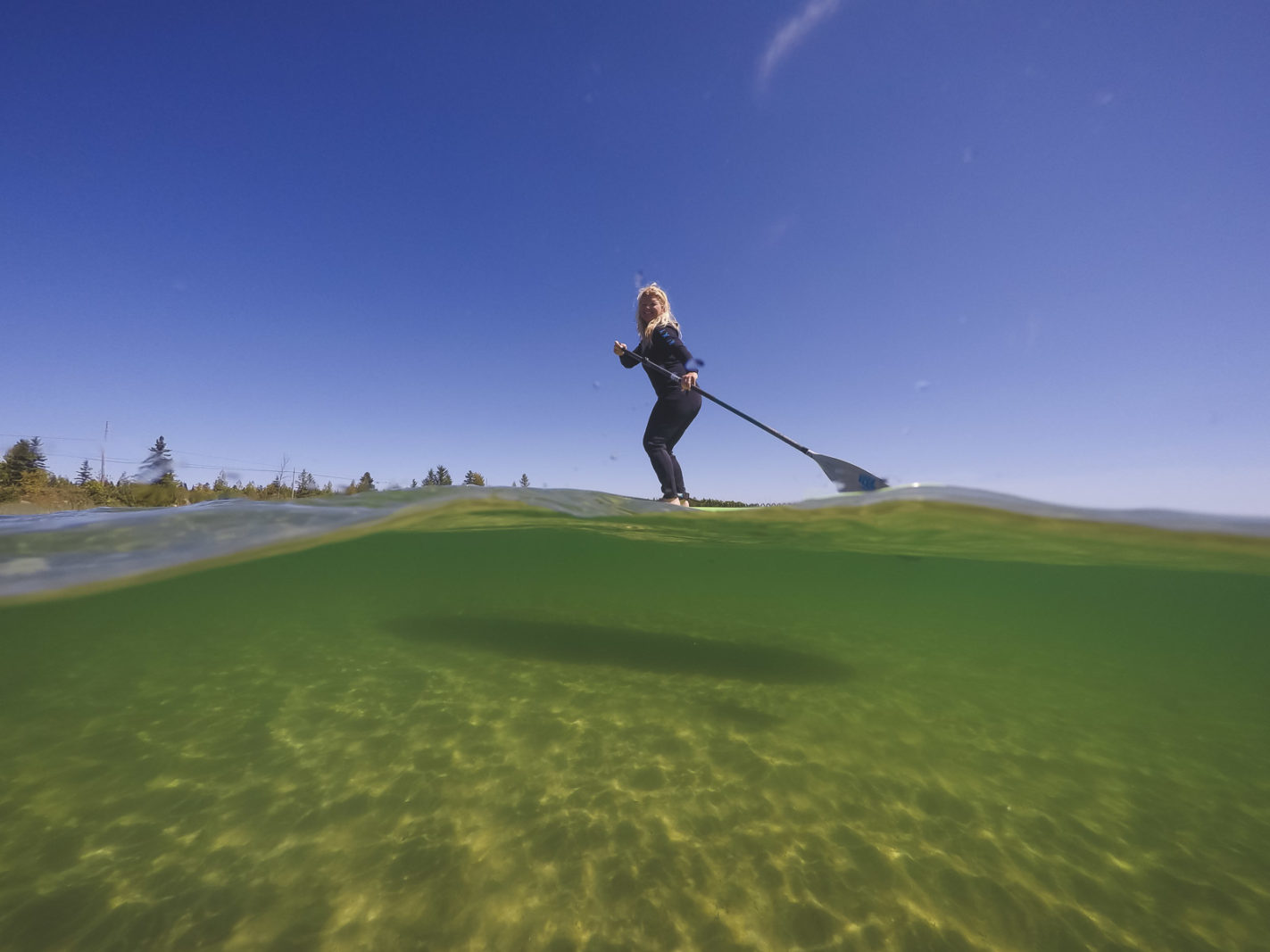 De Stand Up Paddle Boarding on Lake Superior wearing a wet suit