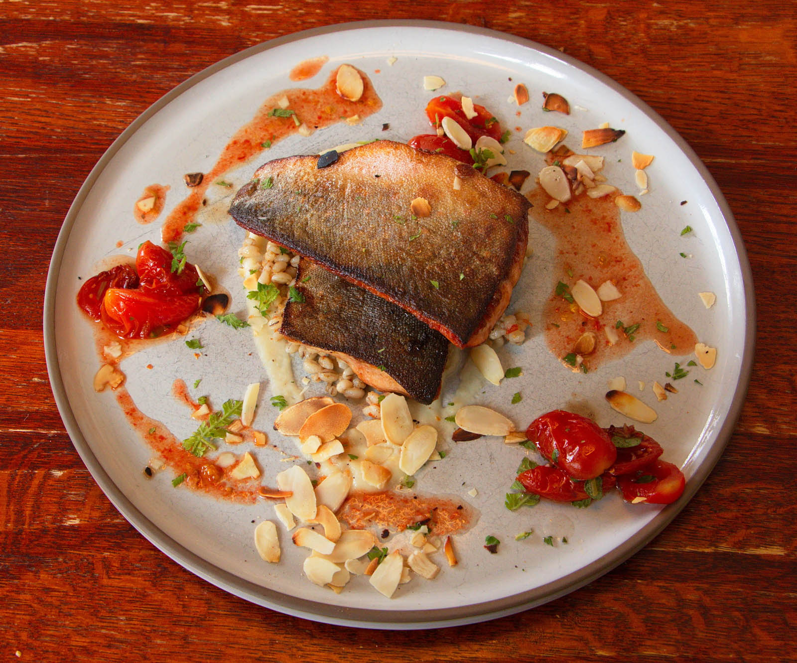 Grilled Arctic char fillet with tomatoes and almonds served in Seyðisfjörður, Iceland.