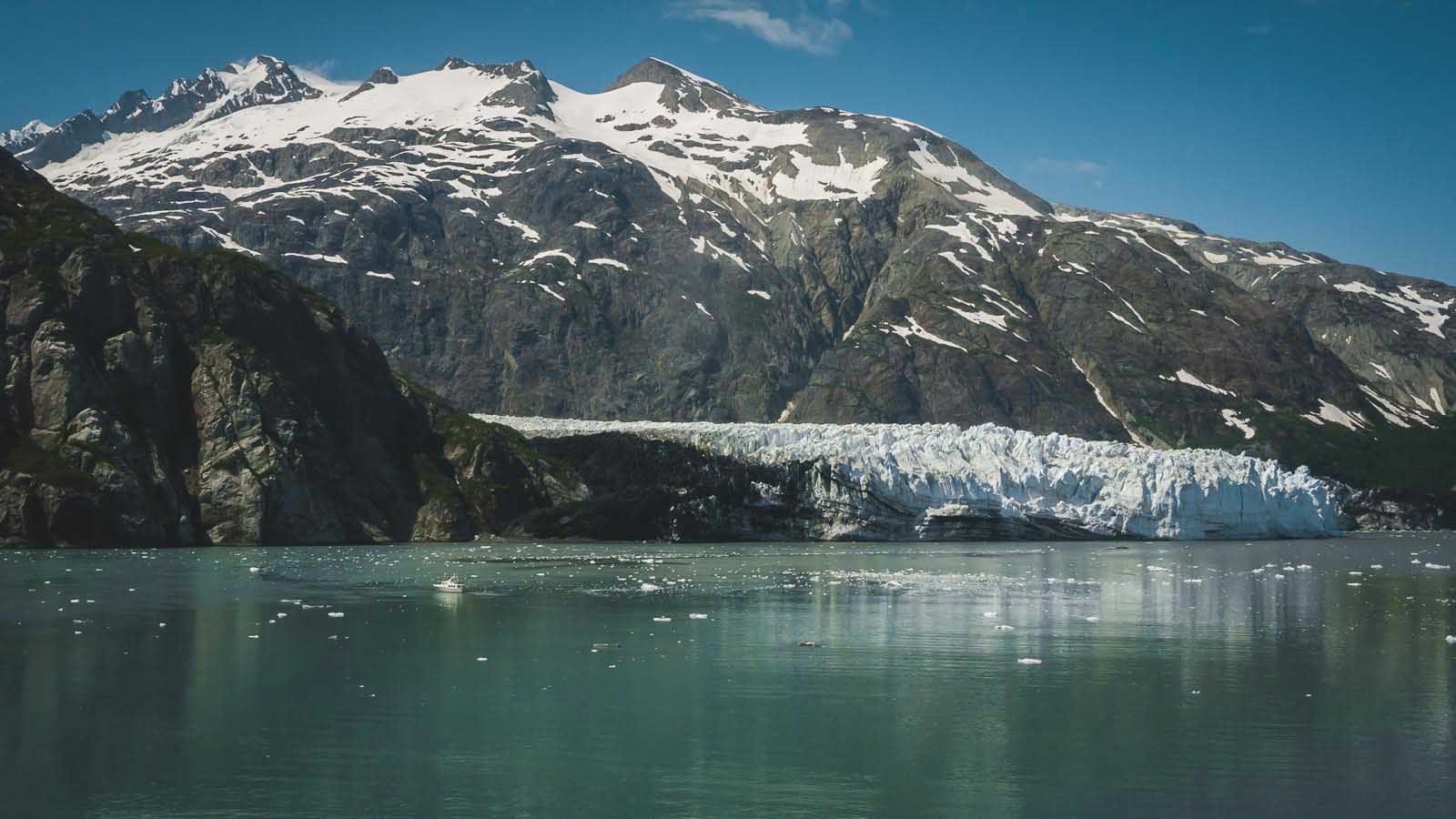 A large tidewater glacier calving a chunk of ice into the calm waters of Glacier Bay National Park, Alaska.
