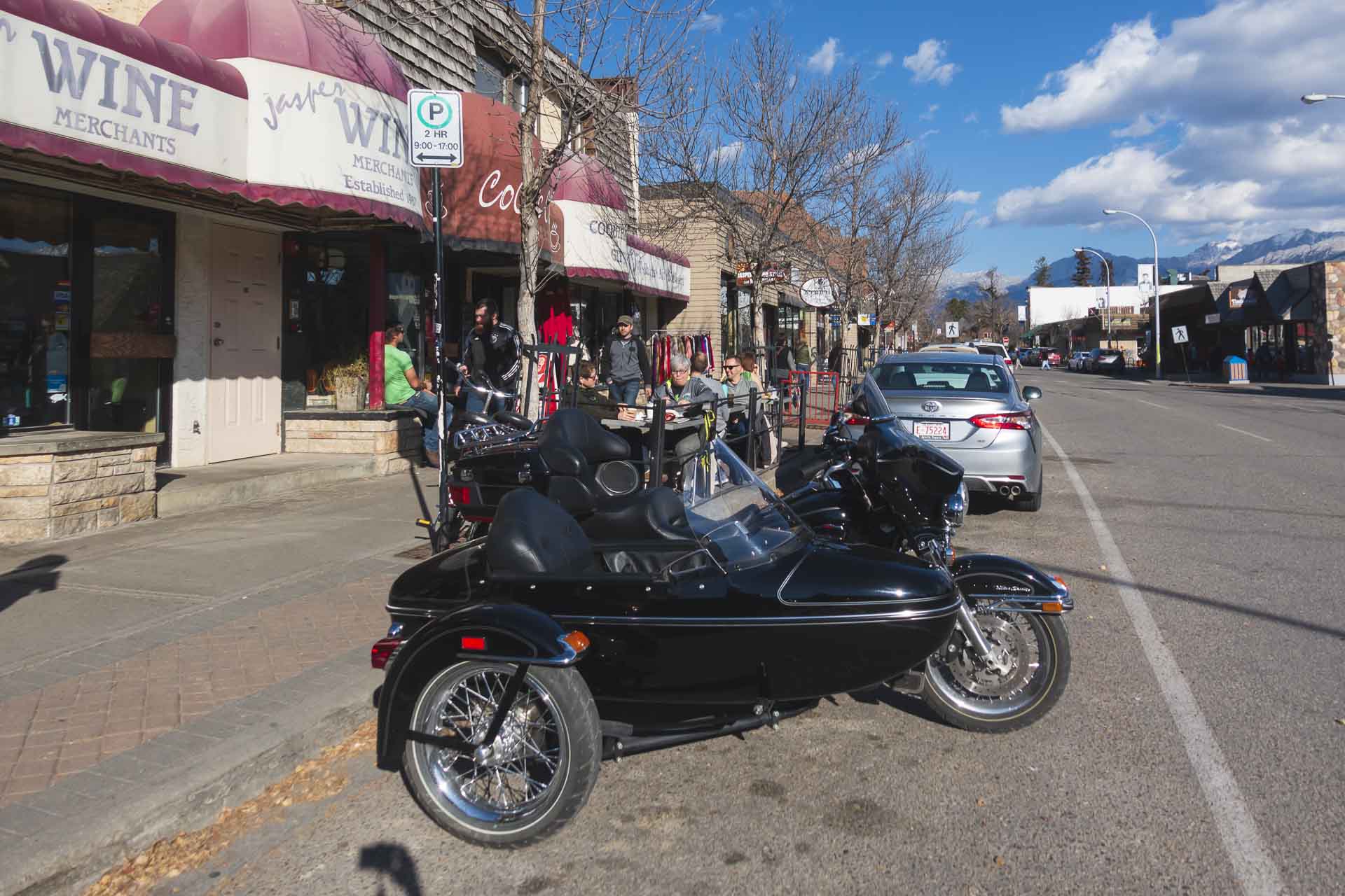 The charming main street of Jasper town, with shops, restaurants, and mountains visible in the distance.