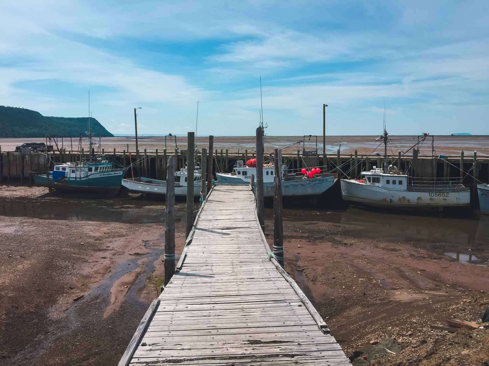 Fishing boats sit on the ocean floor at low tide in Hall's Harbour in Nova Scotia