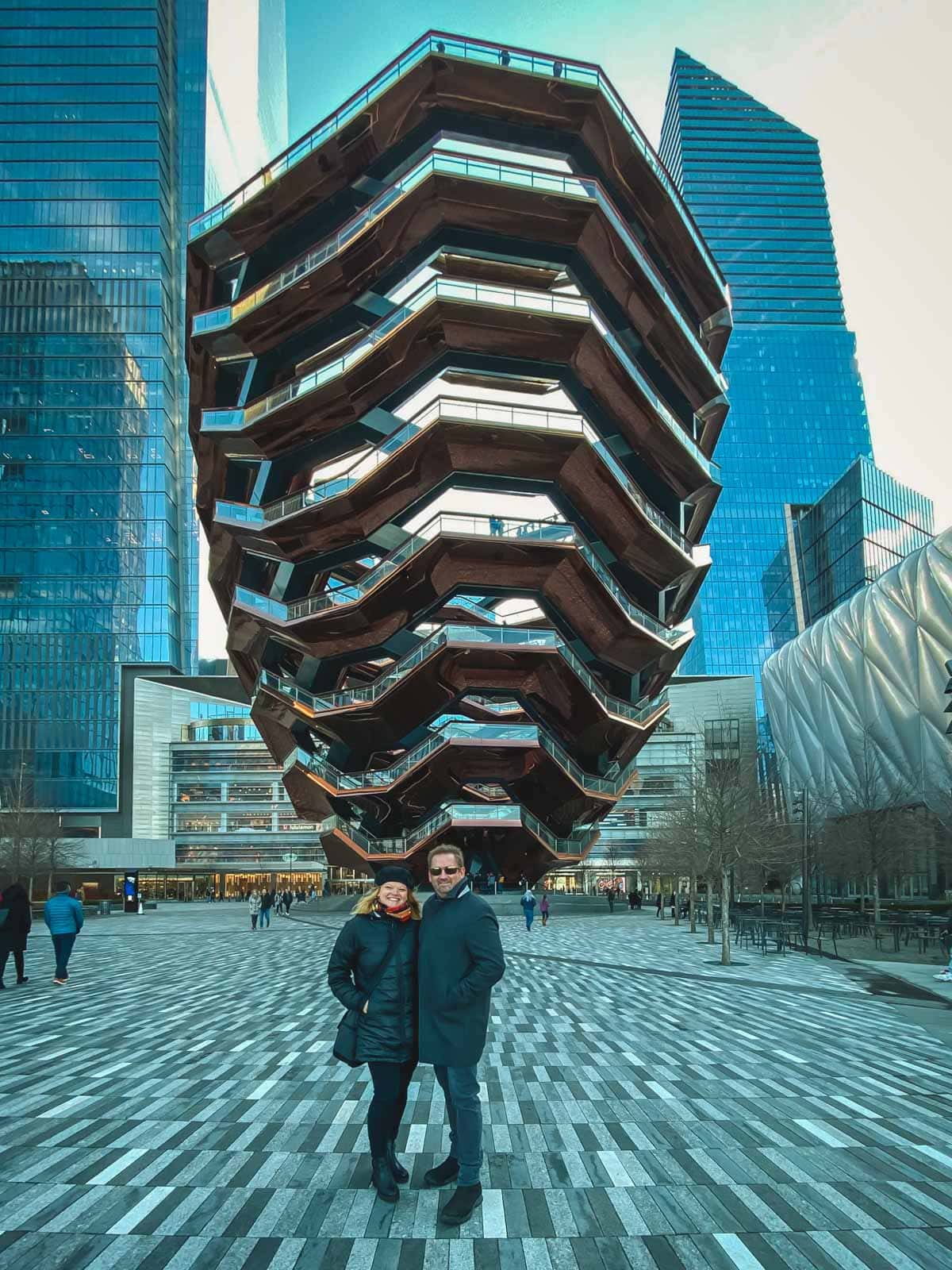 Dave and Deb from The Planet D, bundled up in winter gear and smiling, while visiting New York City at Christmas.